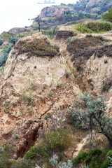 Landslide zone on Black Sea coast. Rock of sea rock shell. Zone of natural disasters during rainy season. Large masses of earth slip along slope of hill, destroy houses. Landslide - threat to life