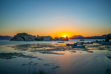 Fototapeta premium Amazing sunset view of Bafa lake is a peaceful place, ringed by traditional villages such as Kapıkırı full of fisherman boats and ruins of Herakleia