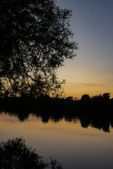 Fototapeta premium Summer Sunrise reflections over peaceful English lake with nobody in view