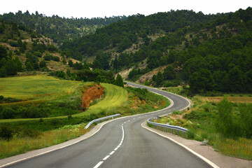 Fototapeta na wymiar Driving on a winding road in a green environment