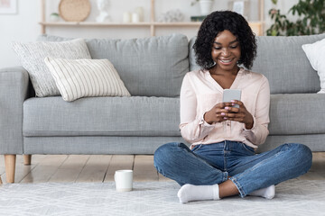 Free Time At Home. Happy Black Woman Resting With Smartphone And Tea