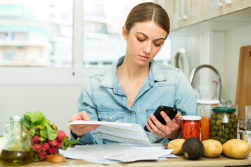 Woman counting money for paying bills at kitchen. High quality photo