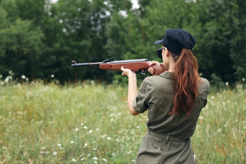Woman Weapon aiming hunting target rear view weapons green trees 
