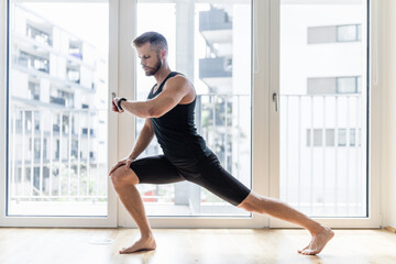 Fototapeta premium Man practicing yoga at his home