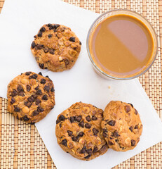cookies with chocolate and hazelnuts and coffee with milk lie on the table
