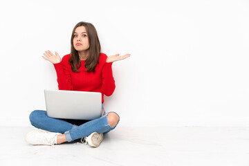 Tenaager girl working with pc isolated on white background making doubts gesture