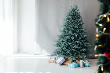 The interior of the white room with a blue Christmas tree with gifts for the new year decor winter postcard