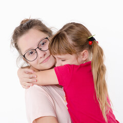 Two sisters hugging, Studio portrait on white background