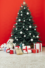 Interior with blue Christmas tree with gifts for the new year decor winter postcard red background