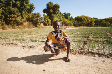African Black Boy Proudly Sits in front of Agriculture Camp in Bamako, Mali