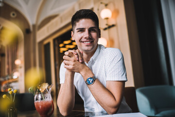 Positive man with cocktail in cafe
