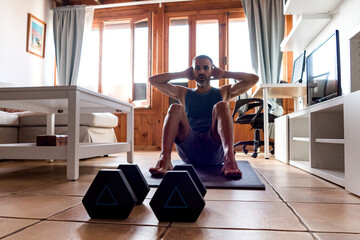 Spanish caucasian man doing abs on a mat at home