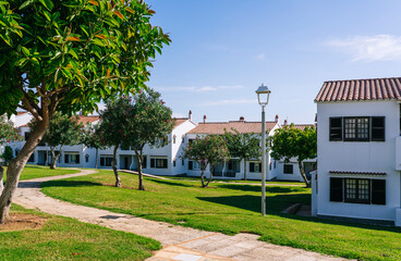 Tourist apartments with white facade with green grass and blue sky on a sunny day