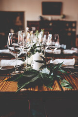 Wedding banquet, serving wooden table with silver plates and decorated with flowers