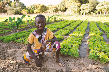 Little Black African Boy Child Smiling in front of Agricultural Camp in Bamako, Mali