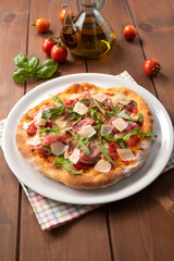 Deliziosa pizza con prosciutto crudo di Parma, rucola e scaglie di formaggio grana, Cucina Italiana
