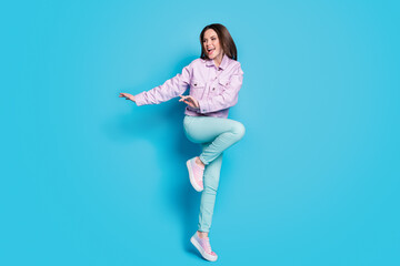Fototapeta na wymiar Full body photo of attractive funny lady raise hands leg dancing students party good mood rejoicing wear casual denim violet jacket pullover pants shoes isolated blue color background