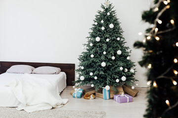 Christmas tree in the interior of the bedroom with a bed and pads for the new year