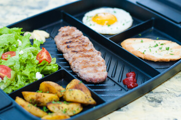 Breakfast, fried steak or cutlet, salad with tomato and green vegetables, toast, potato, egg closeup, light background. Concept healthy eating, diet, menu, nutritious food.