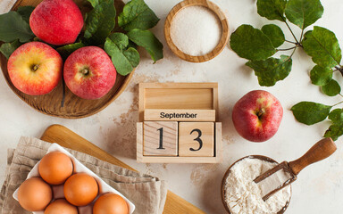 Banner with a wooden calendar on September 13 and ingredients for making Apple pie. Holiday of autumn pies and Charlotte