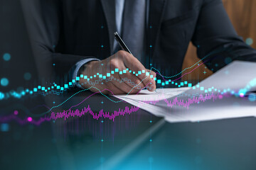 Businessman in suit signs contract. Double exposure with forex graph hologram. Man signing...
