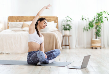 Home Sport. Fit Asian Girl Training In Front Of Laptop, Stretching Muscles