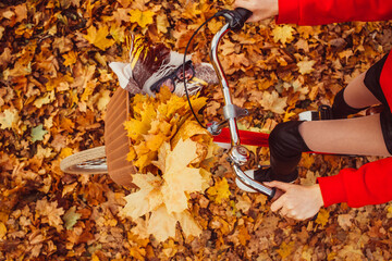 Portrait of a pretty girl with a red bike in the autumn forest