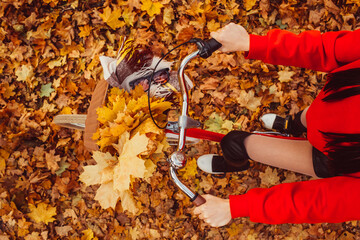 Portrait of a pretty girl with a red bike in the autumn forest