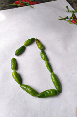 Green chilli making a "D" Shape in a white background