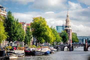 Fototapeta na wymiar downtown Amsterdam with the Montelbaanstoren tower and péniche barges on a canal
