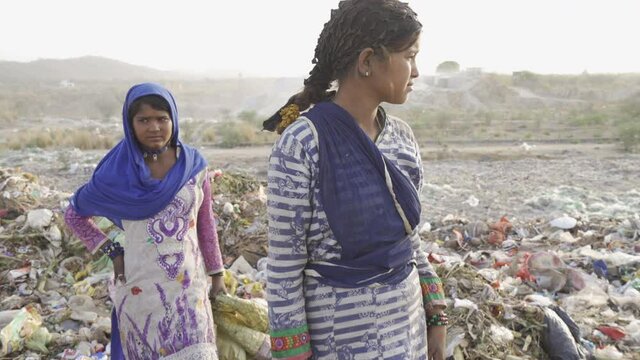 Young people working on landfill site recycling plastics and cardboard. India.