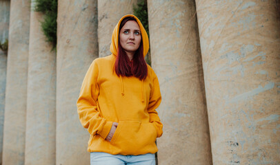 City portrait of handsome beautiful plus size girl wearing casual yellow blank hoodie or sweatshirt with space for your logo or design. Mockup for print