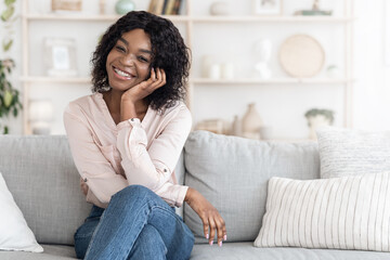 Home Portrait Of Beautiful African Woman Posing On Couch In Stylish Interior