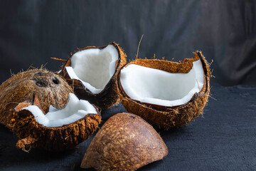 Coconut cut in half on a black background