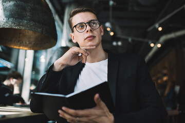 Dreamy man thinking about book