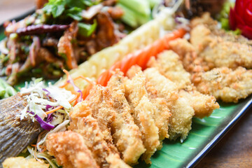 sea bass fish fillet cooked food Thai style Asian - Salad seabass fried fish crispy decorated on plate served on wooden table food dinner