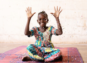 African Fun Party Girl, smiling woman throwing confetti, against a White background with Copy Space