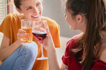 Smiling best friends toasting and sitting at home