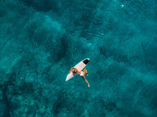 Attractive surfer woman on surfboard in ocean. Aerial view