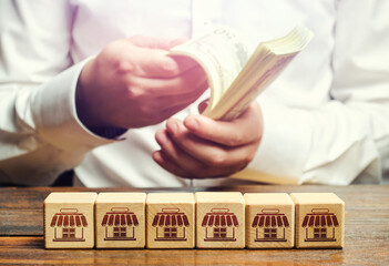 Blocks symbolizing business network and businessman counting money. Building a successful business...