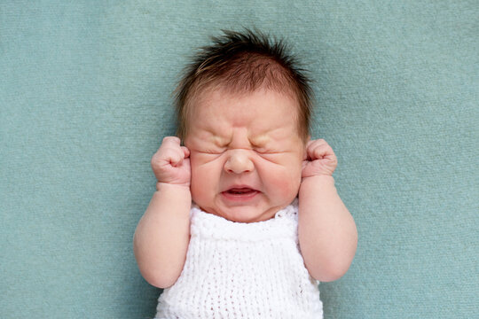 portrait of crying newborn baby. emotions of discontent. colic. 