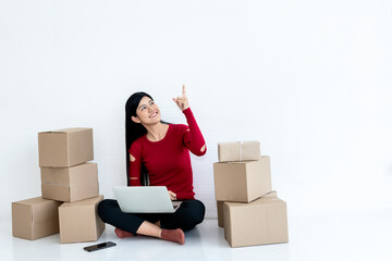 Asian attractive woman pointing and looking up, There were packages on the ground all around, concept to people Running a business to sell products online or SME, Entrepreneur