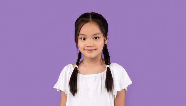 Cute Asian Kid Girl Posing Standing Over Purple Background, Studio