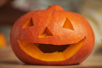 Close-up shot Jack-O'-Lantern carved out of orange ripe pumpkin for Halloween party at home