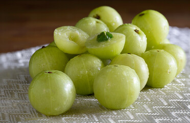 Indian Gooseberry fruit on white table cloth and wooden table