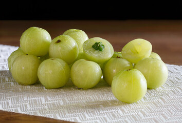 Indian Gooseberry fruit on white table cloth and wooden table