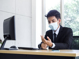 Fototapeta premium Young Asian businessman pain while using notebook computer in office.
