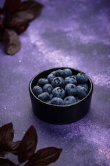 Fresh ripe blueberry on purple background