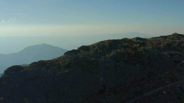 Aerial shot Macedonia. Drone flying over Pelister Peak at sunset where you can see the station building on a background of beautiful mountain ranges in the haze.