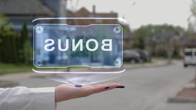 Female hand showing conceptual hologram with Bonus text. Unrecognizable woman in white holds future holographic technology on the background of a street with private houses